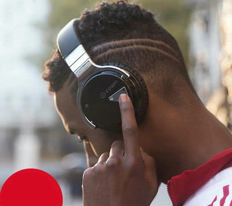 Person wearing headphones with a blurred outdoor background
